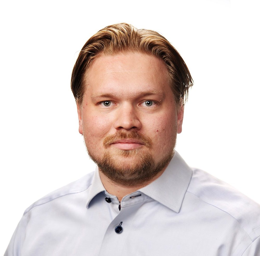 Mannen tittar in i kameran och ler.